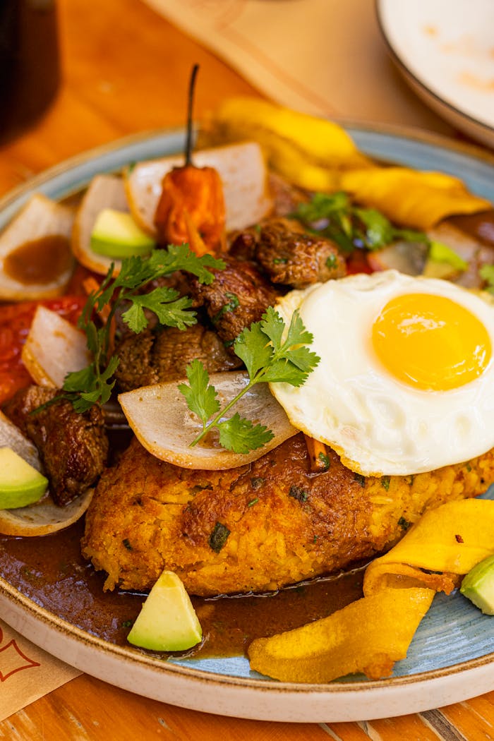 Delicious Peruvian meal featuring a fried egg, meat, and vegetables, showcasing local culinary flavors.