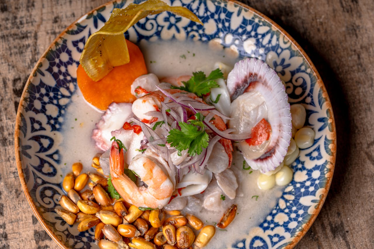 Close-up of vibrant Peruvian ceviche with seafood, corn, and garnishes.