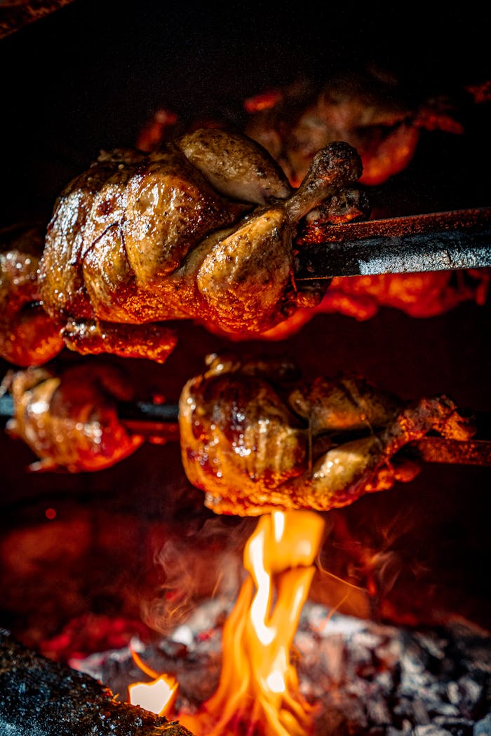 Succulent Peruvian-style chicken roasting over an open flame, showcasing traditional cooking methods.